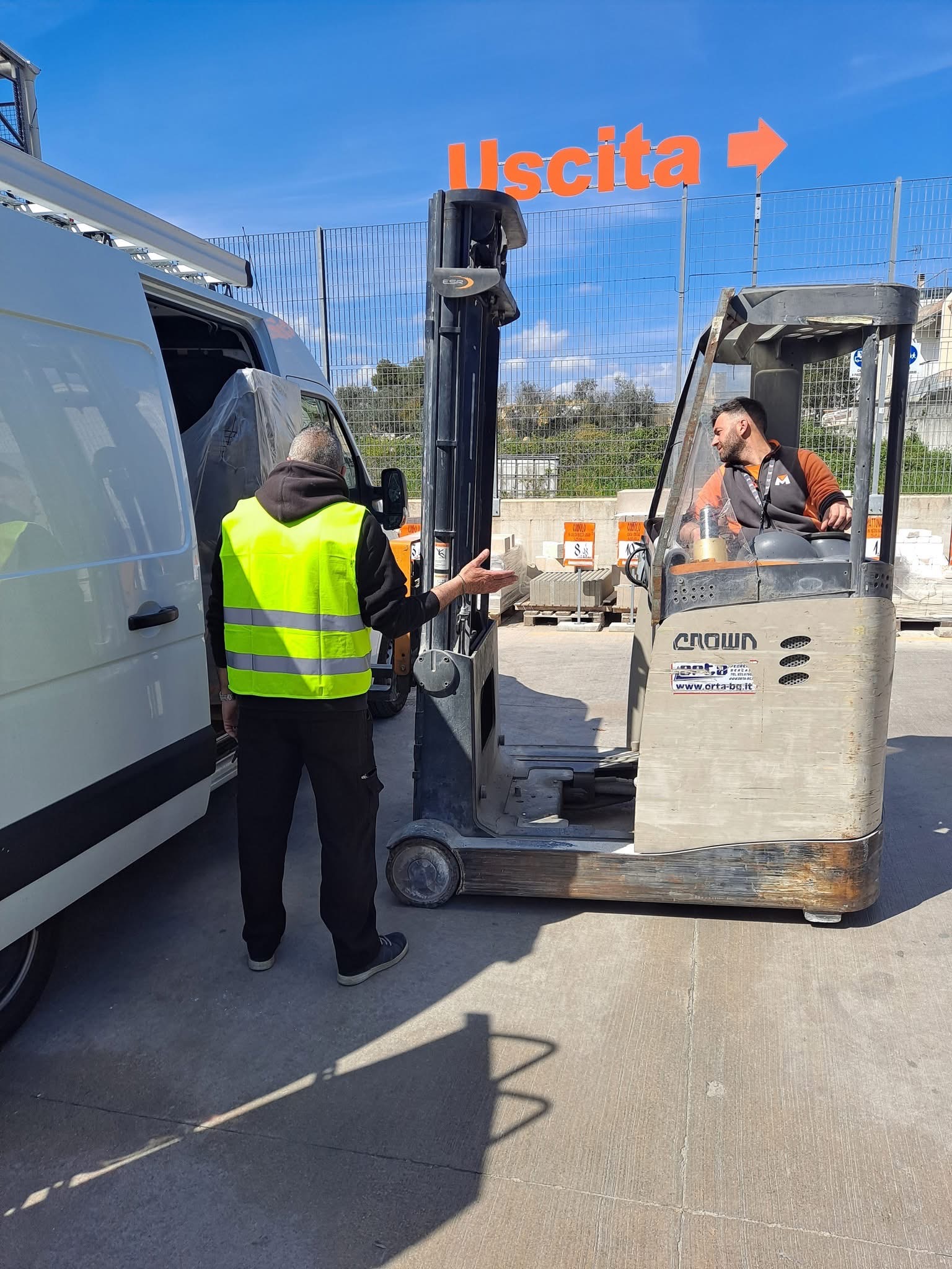 Building materials being loaded into a van with a forklift