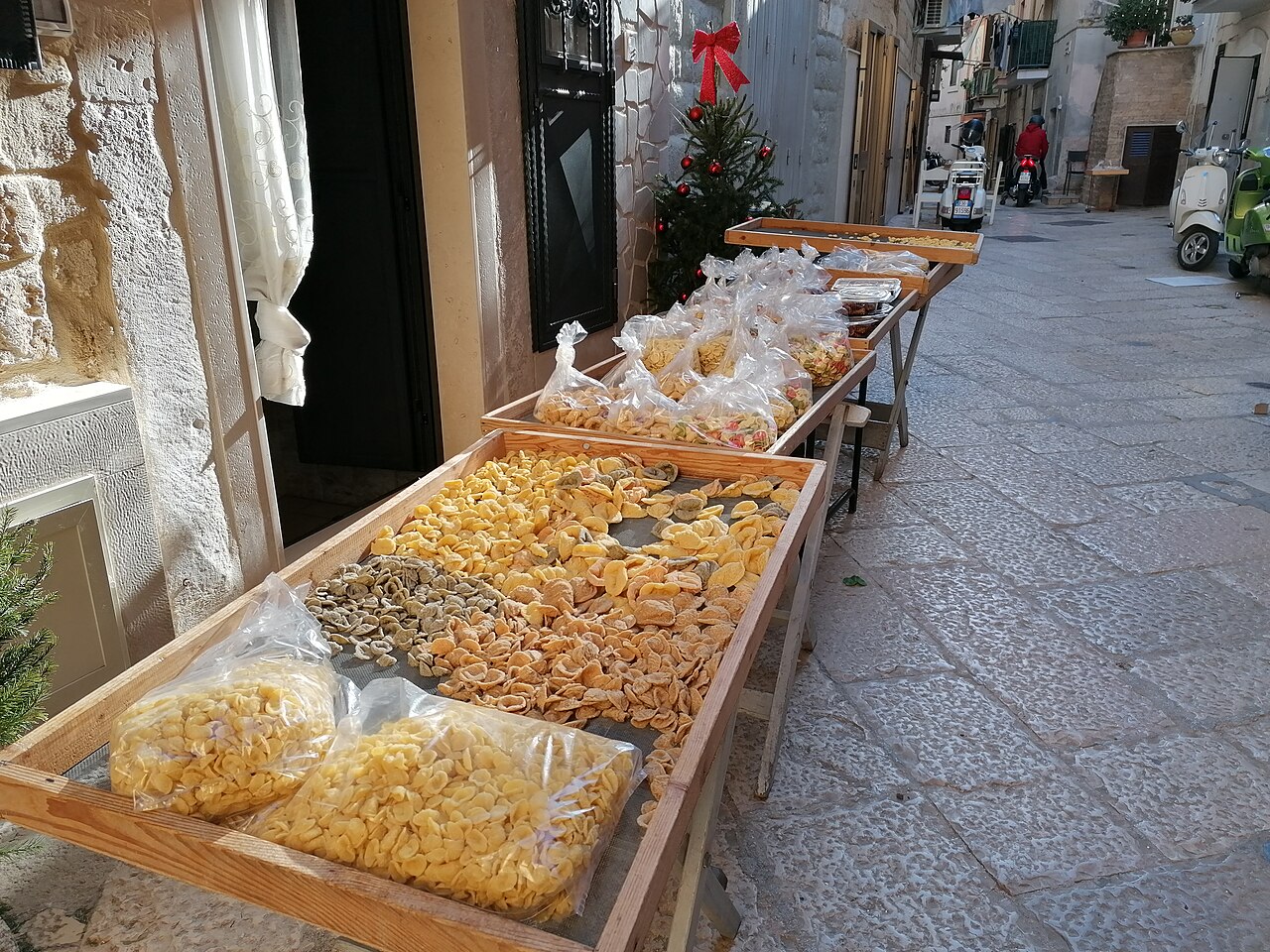 Orecchiette wystawione na drewnianych stołach przy ulicy w Bari Vecchia