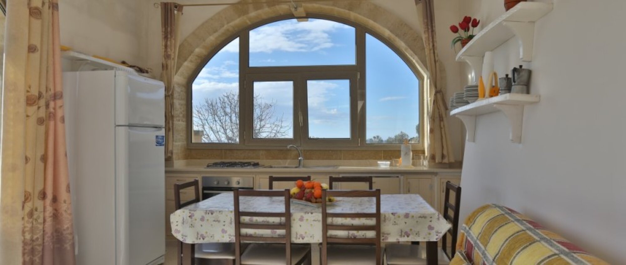 Kitchen with a stone arch and garden view