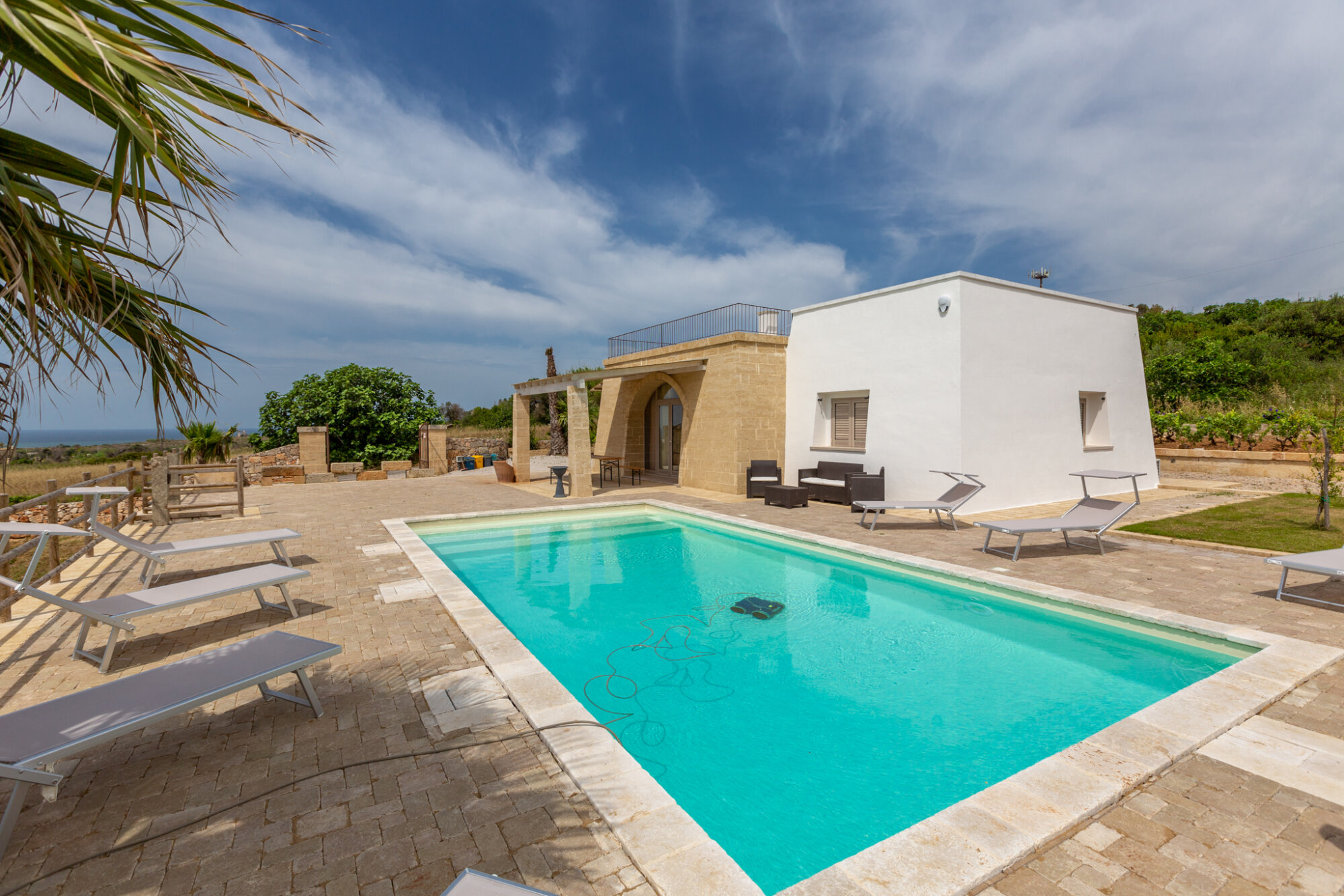Pool and local-stone façade of the villa