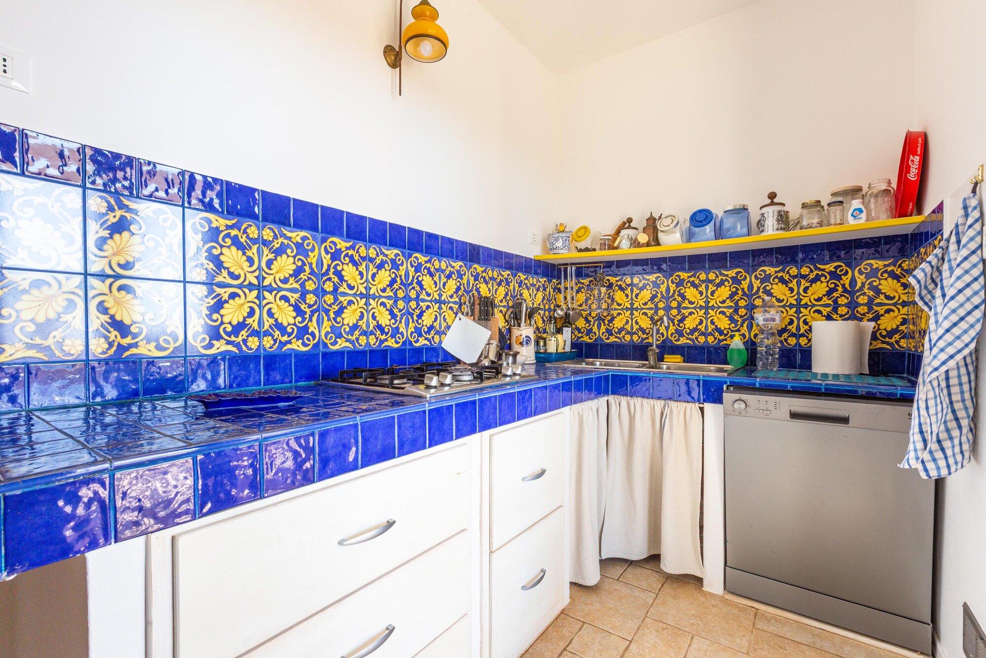 Angolo cottura con ceramiche di Vietri blu e gialle