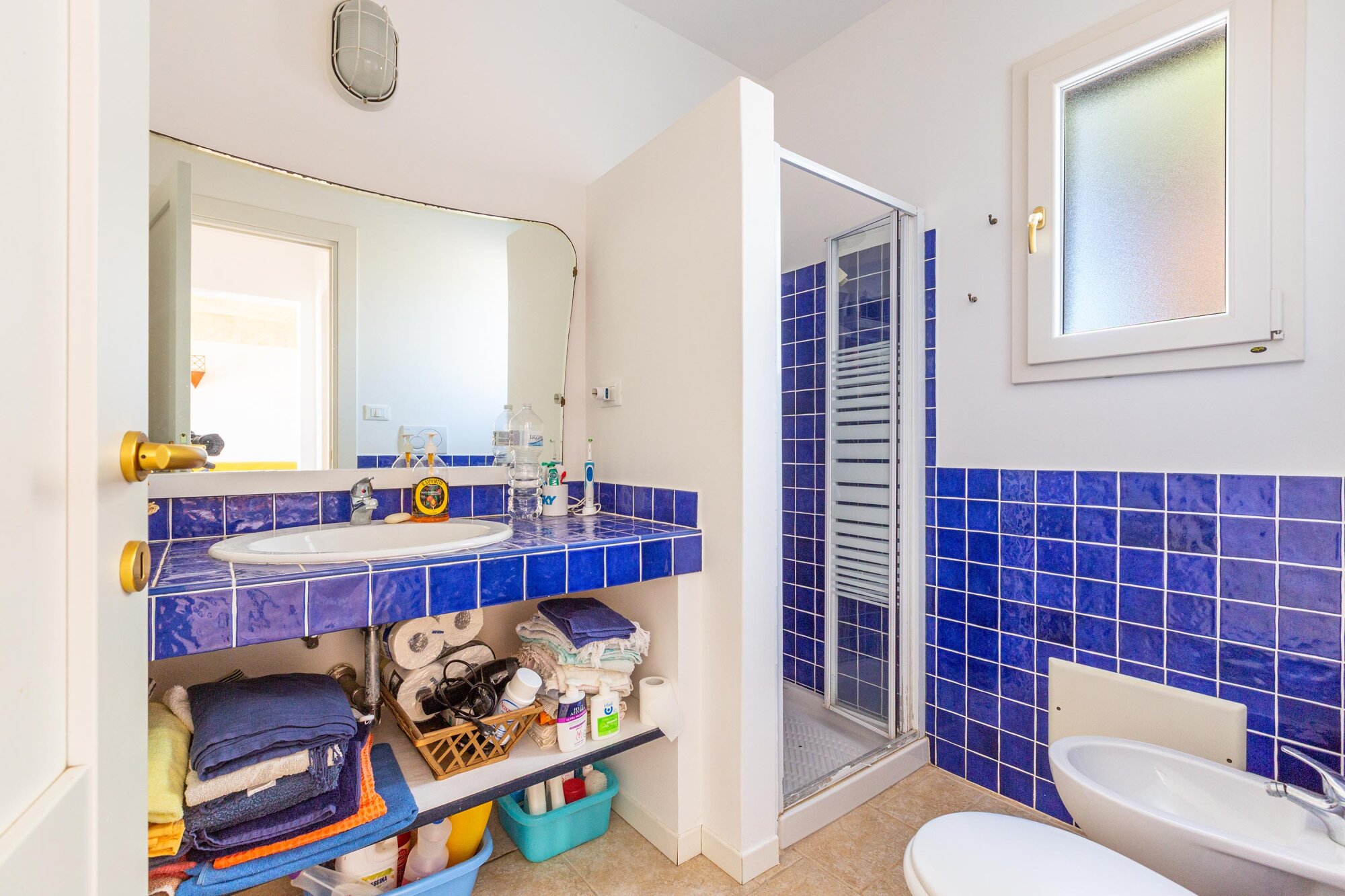 Bagno con doccia e piastrelle blu